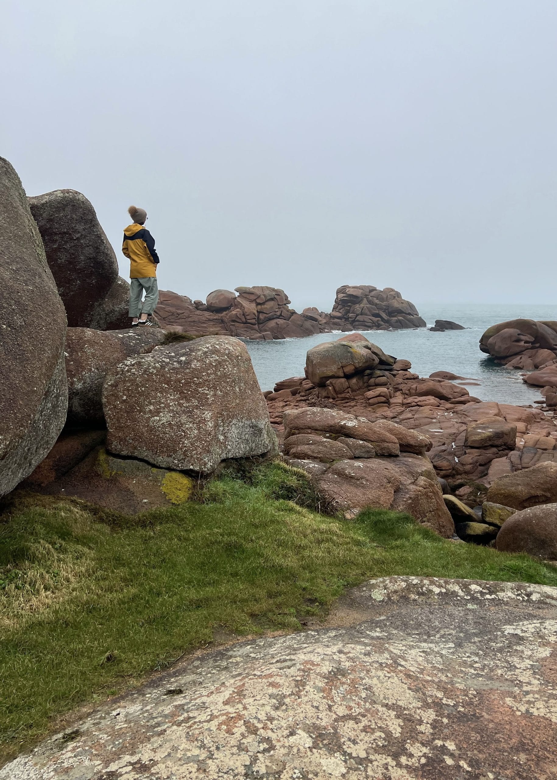 Femme de dos contemplant l’horizon sur la côte de granit rose en Bretagne – photographie introspective et naturelle - Photographe et formatrice photo - Paris